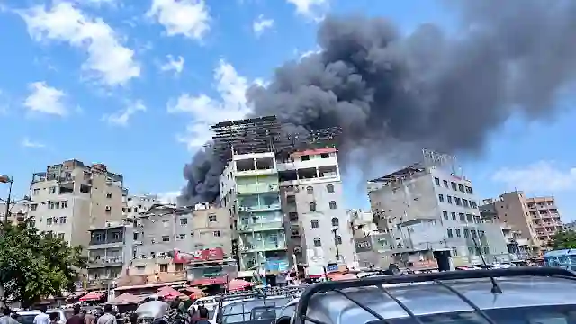 Heavy black smoke rising from damaged rooftops in Gaza following recent airstrikes