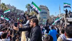 Large crowd waving Syrian opposition flags during public demonstration in Damascus