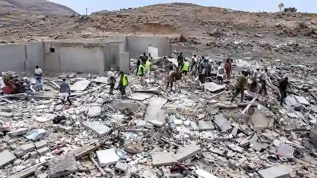 Rescue workers and residents search through rubble of damaged infrastructure in Yemen after airstrikes