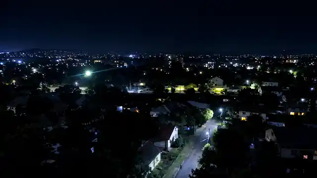 Darkened residential area and city skyline during a power grid blackout after retaliatory strikes